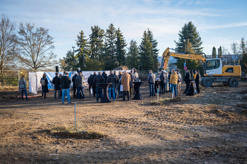 Menschen von hinten beim Spatenstich